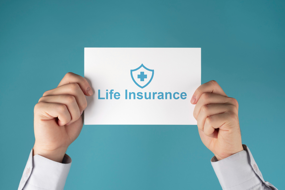 deux mains qui tiennent uhe pancarte blanche avec "Life Insurance" écrit en blau avec un fond bleu, fonds internes dédiés
